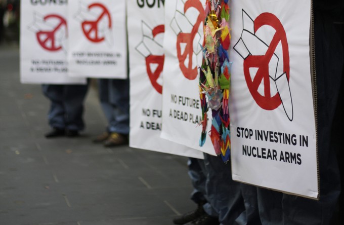 Signs with anti-nuclear messages, eg. "Stop Investing in nuclear arms"